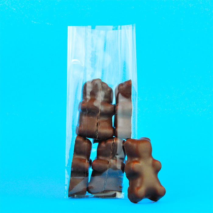 Sachet de six choco-grizzly artisanaux avec un ourson sorti du sachet pour présentation, sur fond bleu
