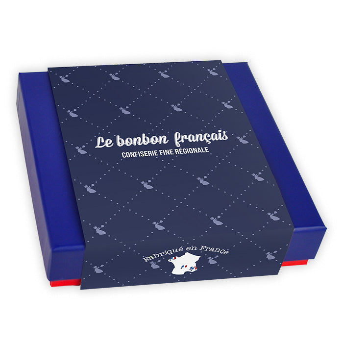 Coffret prestige Le Coq des Français fermé dans son fourreau bleu à motifs répétés avec logo Le Bonbon Français au centre