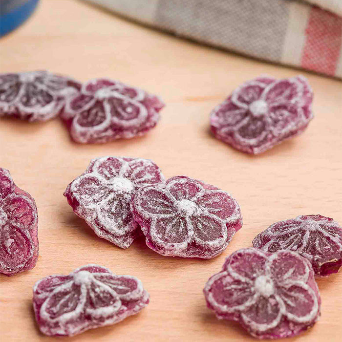Bonbons à la violette d'antan, confiserie artisanale française, présentés sur fond bois